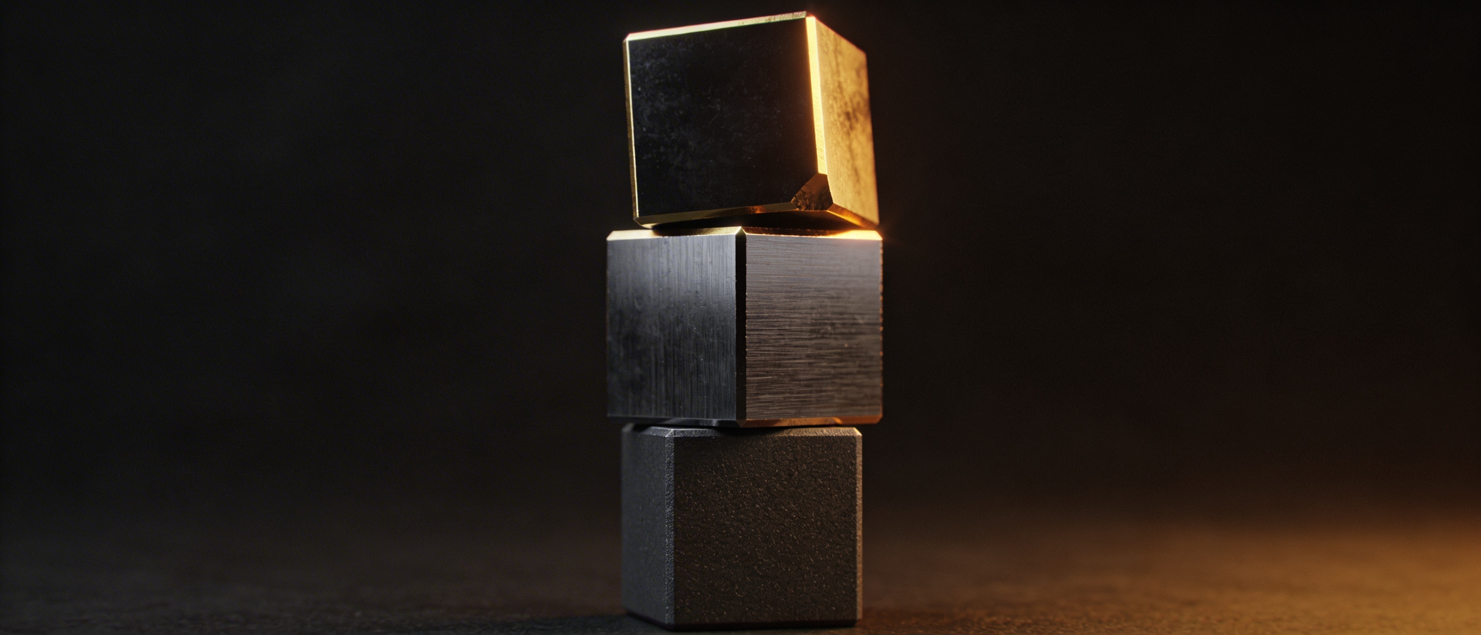 Three dark metallic cubes stacked vertically with gold numerals